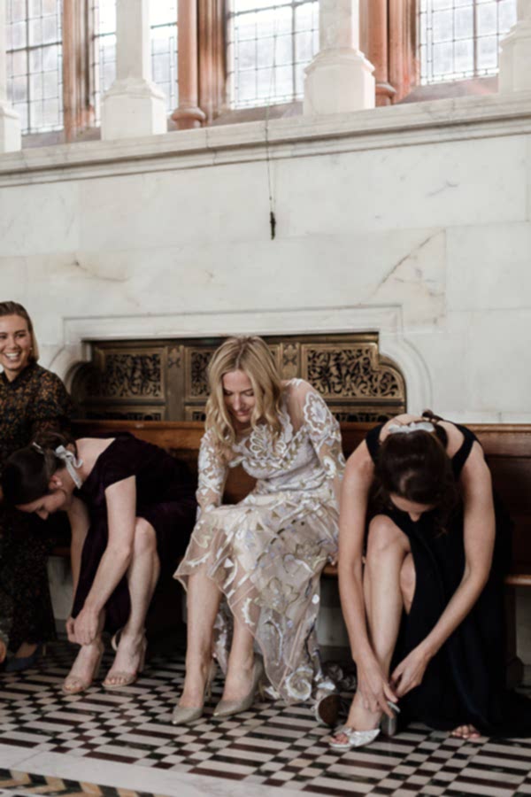 bride with bridesmates putting their shoes on