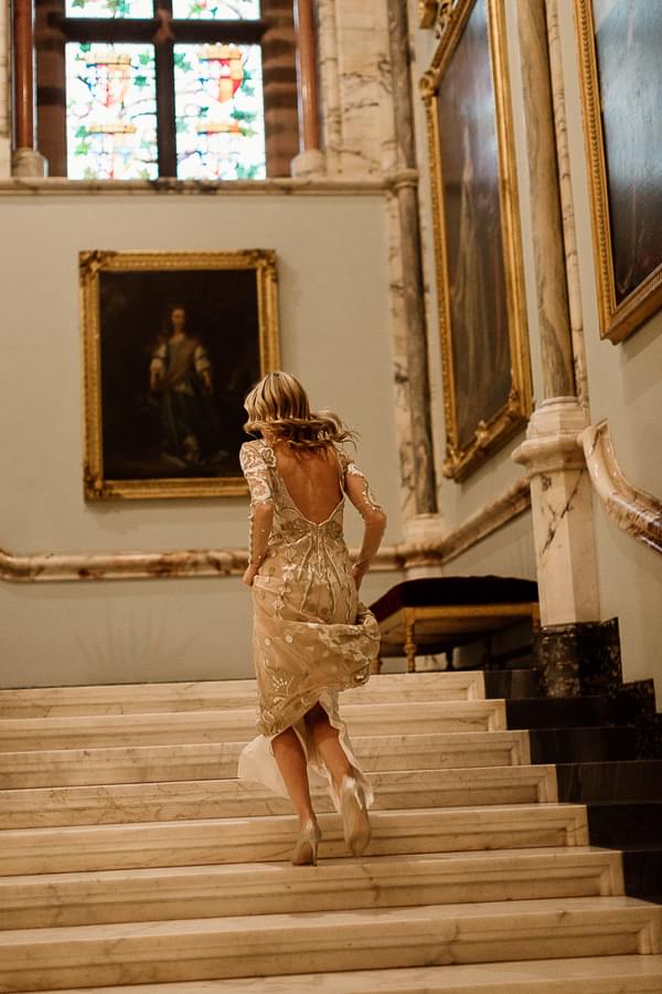 bride running up the stairs to change