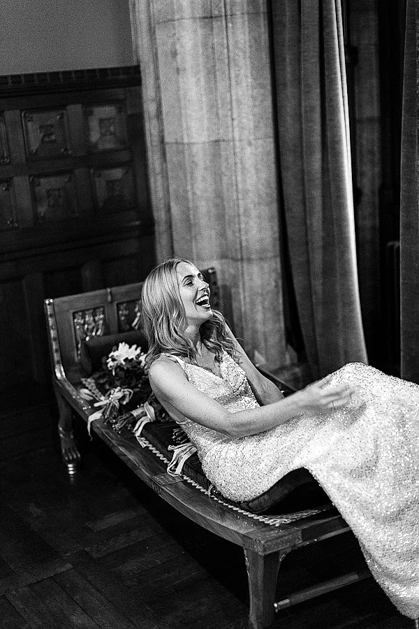 bride laughing on a chair in an evening dress