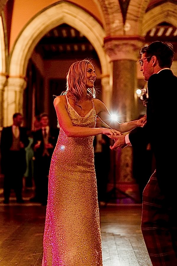 bride and groom dancing and smiling to each other