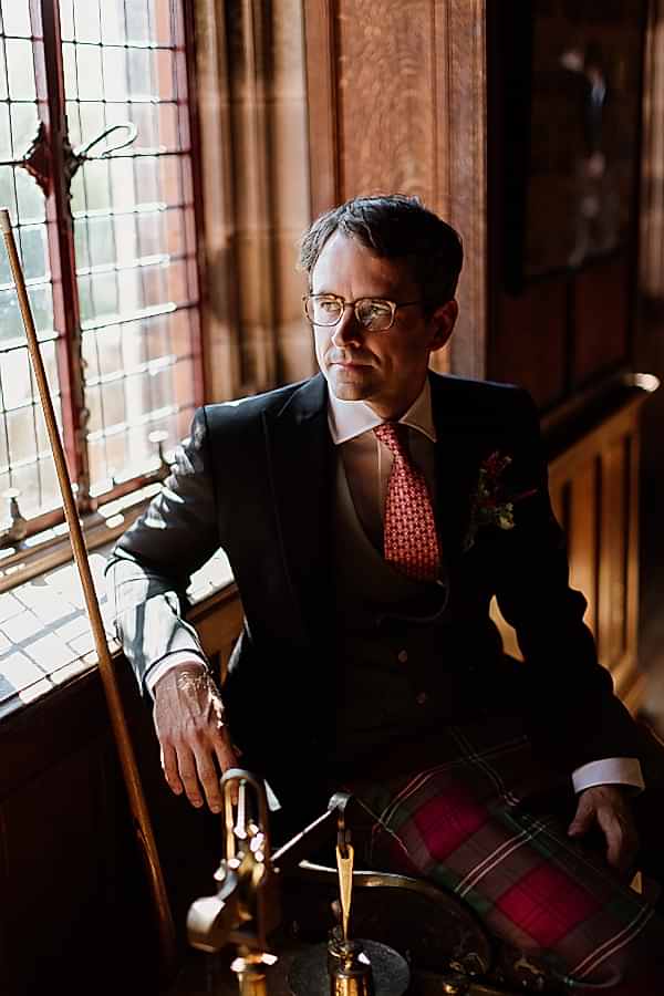 groom looking through a window at pool room bute