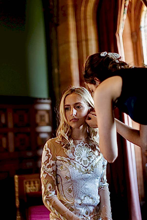 bridesmate putting earling on bride