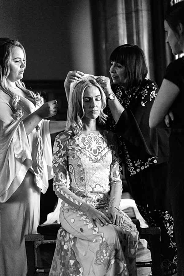mom mounting veil on daughters hair wedding
