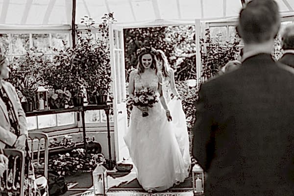 bride walking into a green house atGlenapp Castle for a humanist ceremony