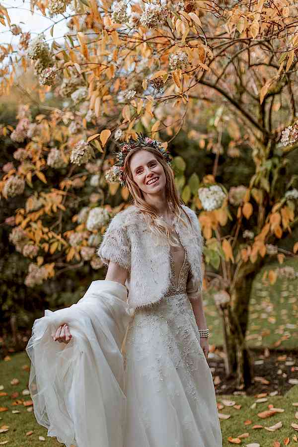 bride holding her dress by the tree at Glenapp Castle Scotland 