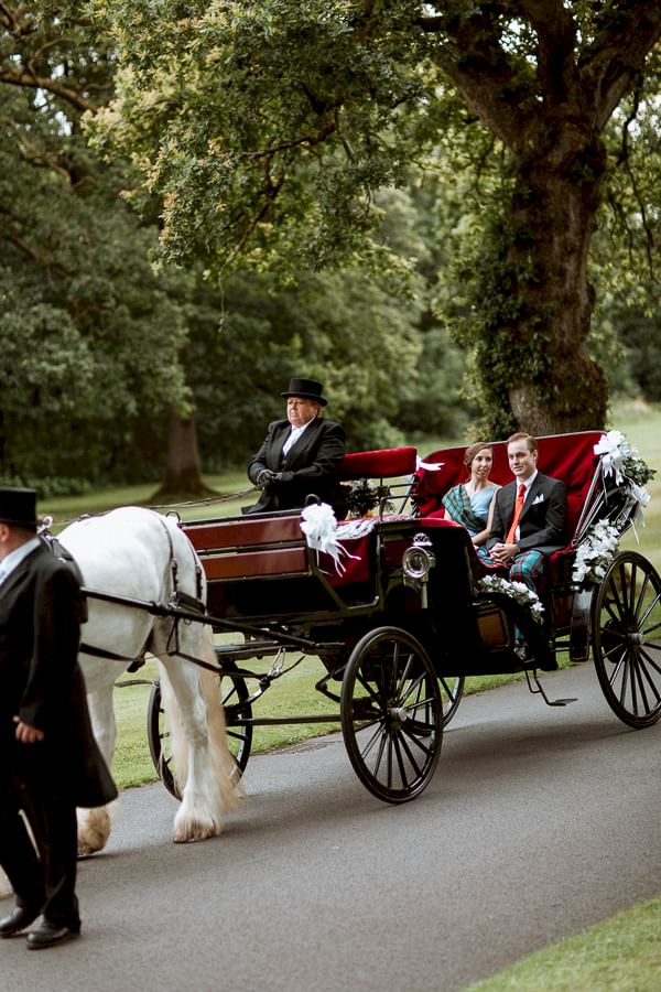 bride and groom arriving to soarn castle with a carriage