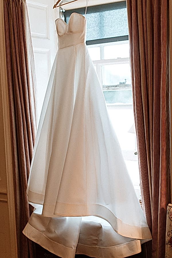 wedding dress hanging on a window at dumfries house