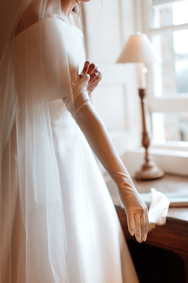 bride putting her long wedding gloves