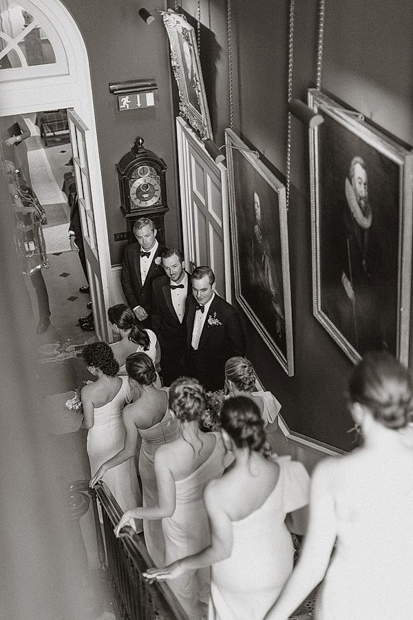 groom looking at bridesmates walking down