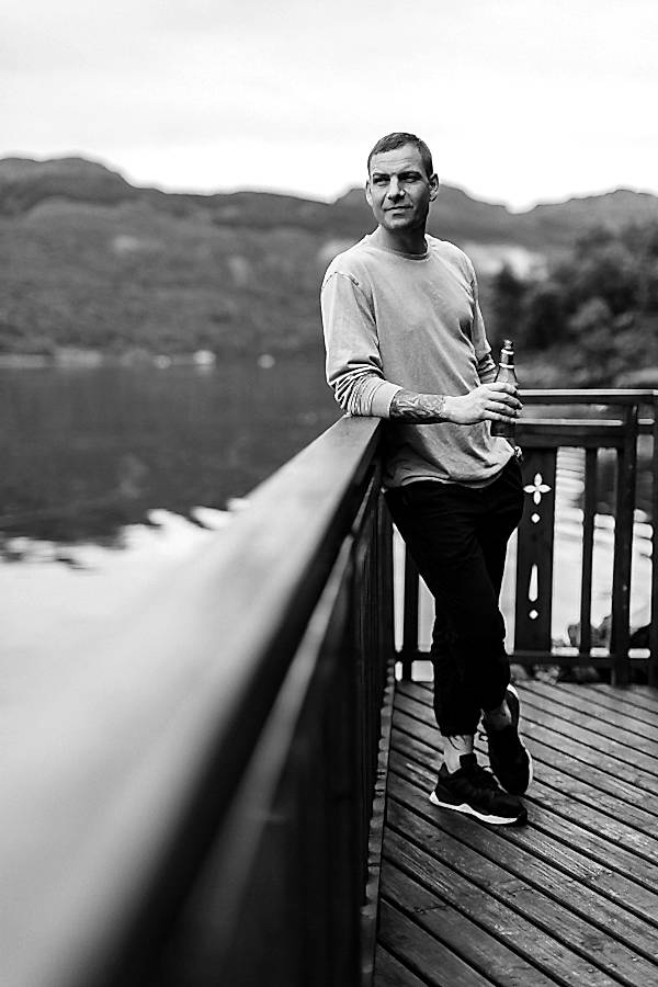 groom in the morning realxing by the shore on loch goil wedding day scotland